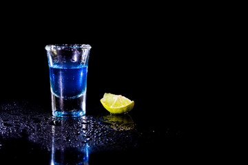 Blue vodka in glass and lemon with salt.
