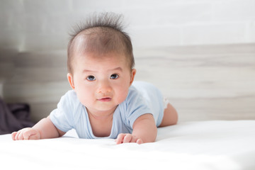 Adorable asian baby boy relaxing on white bed, Baby development stages of 3 month old