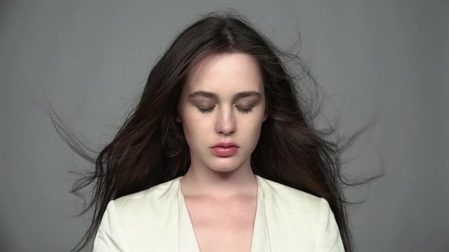 Slow motion video portrait of beauty young brunette resentful, woman with green eyes and streaming hair