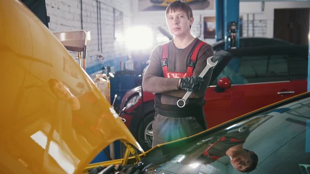 Portrait of a young car mechanic in a car workshop