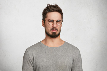 Negative human expressions and attitude. Angry dissatisfied male has disgusting expression as sees...