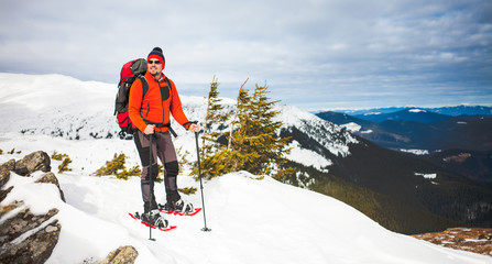 Male tourist in snow snowshoes.