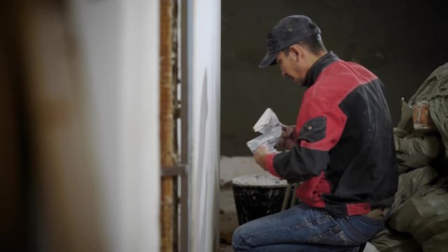Man working on finishing interior and applying stucco on wall