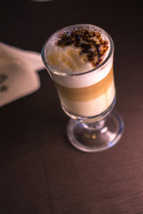 Coffee in a glass cup in a cafe with a blurred background.