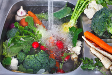 Vegetables washing, splashing water, fresh vegetables preparation for cooking. Vegetarian food.