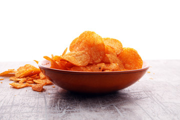 Crispy potato chips in a bowl. Tasty paprika chips.
