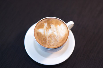 A cup of coffee with a picture in a cafe.