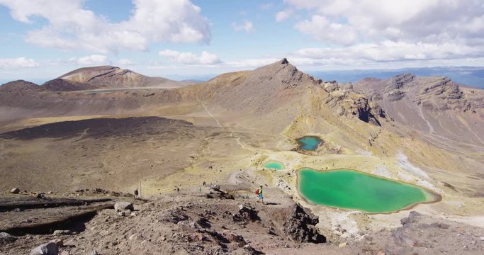New Zealand Nature Landscape With Hiker Hiking In Tongariro National Park Ejoying view of Emerald Lakes from summit of Tongariro Alpine Crossing, a famous tourist attraction in New Zealand.