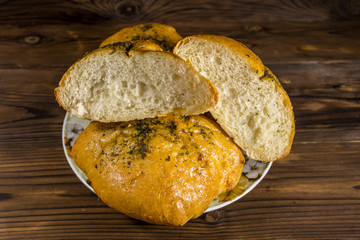 Fresh bread ciabatta on a plate on wooden table