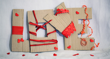 cardboard love sign with red ribbon