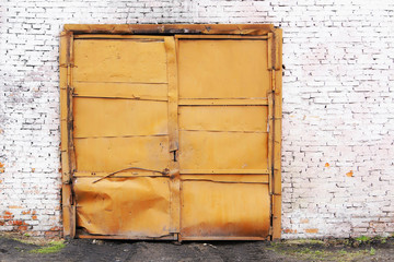 Old garage metal gate in a brick wall