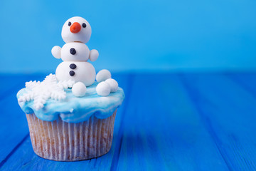 Funny homemade New Year party cupcake with snowman decoration made of confectionery mastic, free...