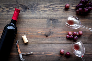Obraz na płótnie Canvas Open wine bottle. Grape and corkscrew on dark wooden background top view copyspace
