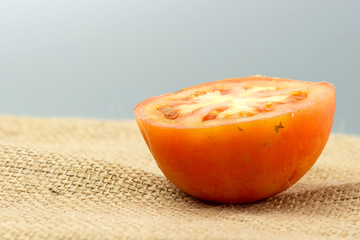 Closeup side view of cut tomato on sack