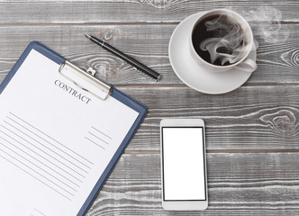 contract, tablet, pen, smartphone, coffee cup on a wooden background. concept of signing a contract. business..
