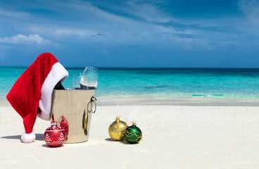 Champagner Kübel mit weihnachtlicher Dekoration an einem tropischen Sandstrand