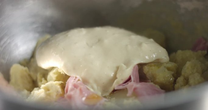Adding ham, bechamel sauce and cheese to homemade potato casserole bread for Christmas dinner
