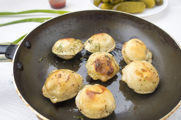 Fried dumplings in a frying pan.