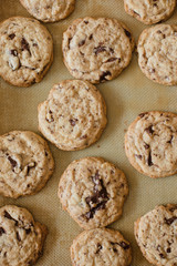 Close up of homemade , traditional American chewy Chocolate Chip Cookies with big semi-sweet chocolate chunks fresh from the oven on non-stick silicone baking mat