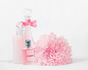 Pastel pink cosmetic mock up bottles product setting  with flower on white background, front view....