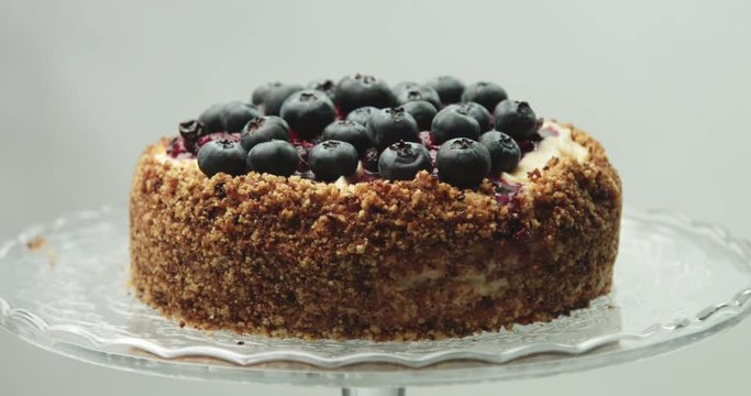 Close up of rotating homemade professional quality vanilla cake with fruit berries compote and fresh blueberries