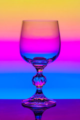 Crystal wine glass on a background of multi colored gradient