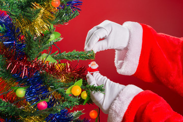 Santa Claus hanging doll to a fir tree