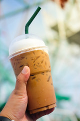 Man hand holding a cup of iced coffee