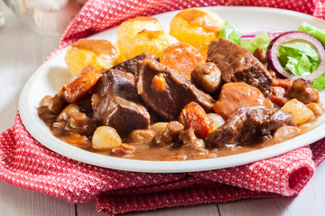Beef Bourguignon stew served with baked potatoes
