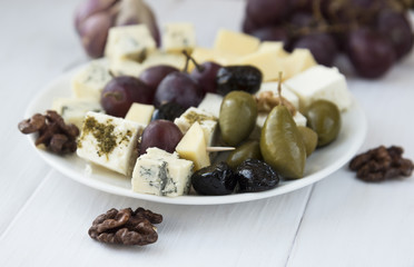 Cheese plate with grapes, olives and nuts