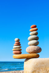 Stones balance on a background of blue sky and sea
