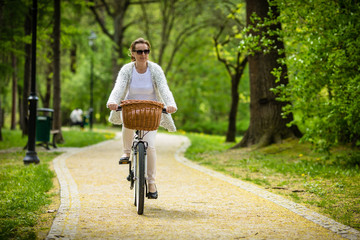 Obraz premium Urban biking - woman riding bike in city park 