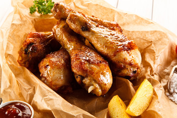     Grilled chicken legs with baked potatoes and vegetables 