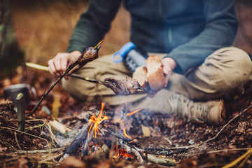 quail on the stick grilled in the fire. delicious forest picnic. bushcraft concept