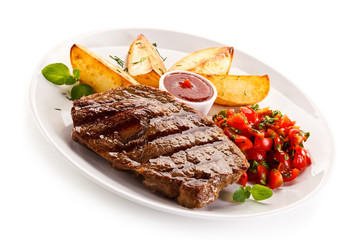 Grilled steak, baked potatoes and vegetable salad on white background 