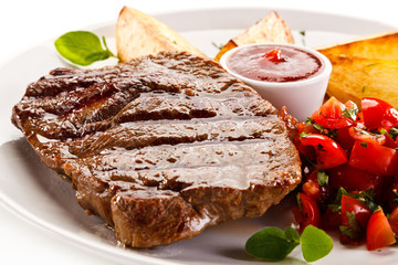 Grilled steak, baked potatoes and vegetable salad on white background 