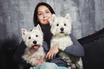 Happy Young girl holding a white Terrier dog.