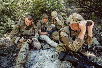 British special forces soldiers with weapon and officer holds a radio station
