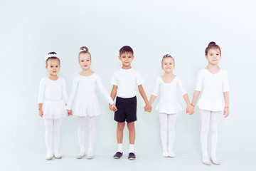 Group of kids boys and girls dancing at a white class room or studio smiling and hugging together