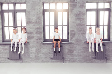 Cute little kids dancers on white background. Choreographed dance by a group of small ballerinas practicing at a classical ballet school