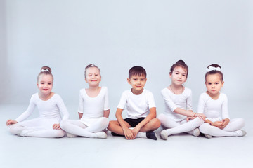 Cute little kids dancers on white background. Choreographed dance by a group of small ballerinas...