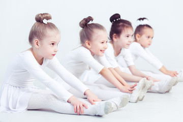 Naklejka premium Group of graceful pretty little ballerinas practicing during class at a classical ballet school their first choreographed dance