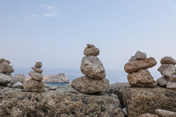 Landscape with small piles of rocks  left there by the visitors as a form of a memento. On the Rhodes Island, Greece