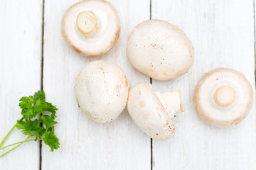 Fresh organic champignon mushrooms on wood background. Flat lay