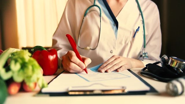 Vegetable diet nutrition and medication concept. Nutritionist writes prescription and offers healthy vegetables diet.