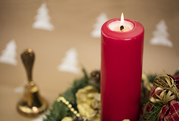 Christmas composition with yule wreath, golden ornaments and red candle.