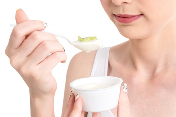 Young woman eating yogurt isolated on white background