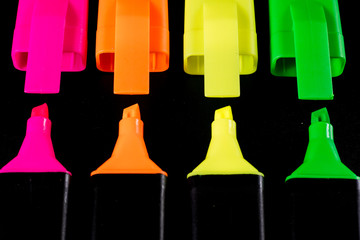 Office Highlighter on a black background. Office Mazak to draw are lying on a black countertop.