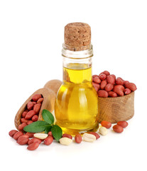 peanut oil in a glass bottle with peanuts in bowl