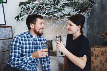 A loving couple celebrating Christmas in atmosphere by the fireplace and Christmas tree.